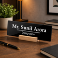 Black acrylic desk name plate showing Mr. Sunil Arora, Designation, on wooden stand