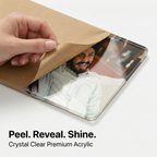 Clear acrylic photo sheet with protective paper being peeled back by hand