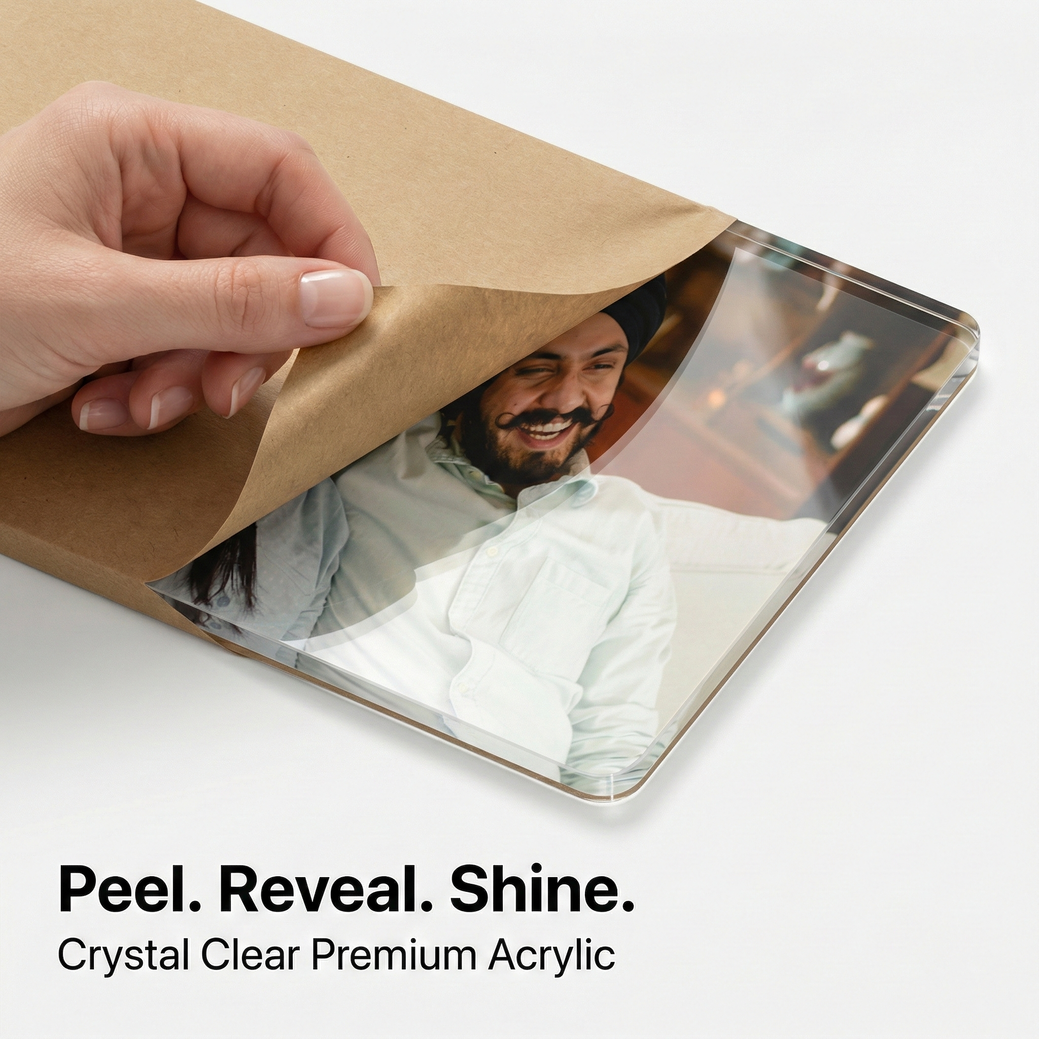 Clear acrylic photo sheet with protective paper being peeled back by hand