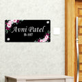 Black door name plate with pink floral corners and name "Avni Patel"