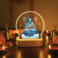 LED desk lamp with glowing arch showing seated baby Shiva meditation