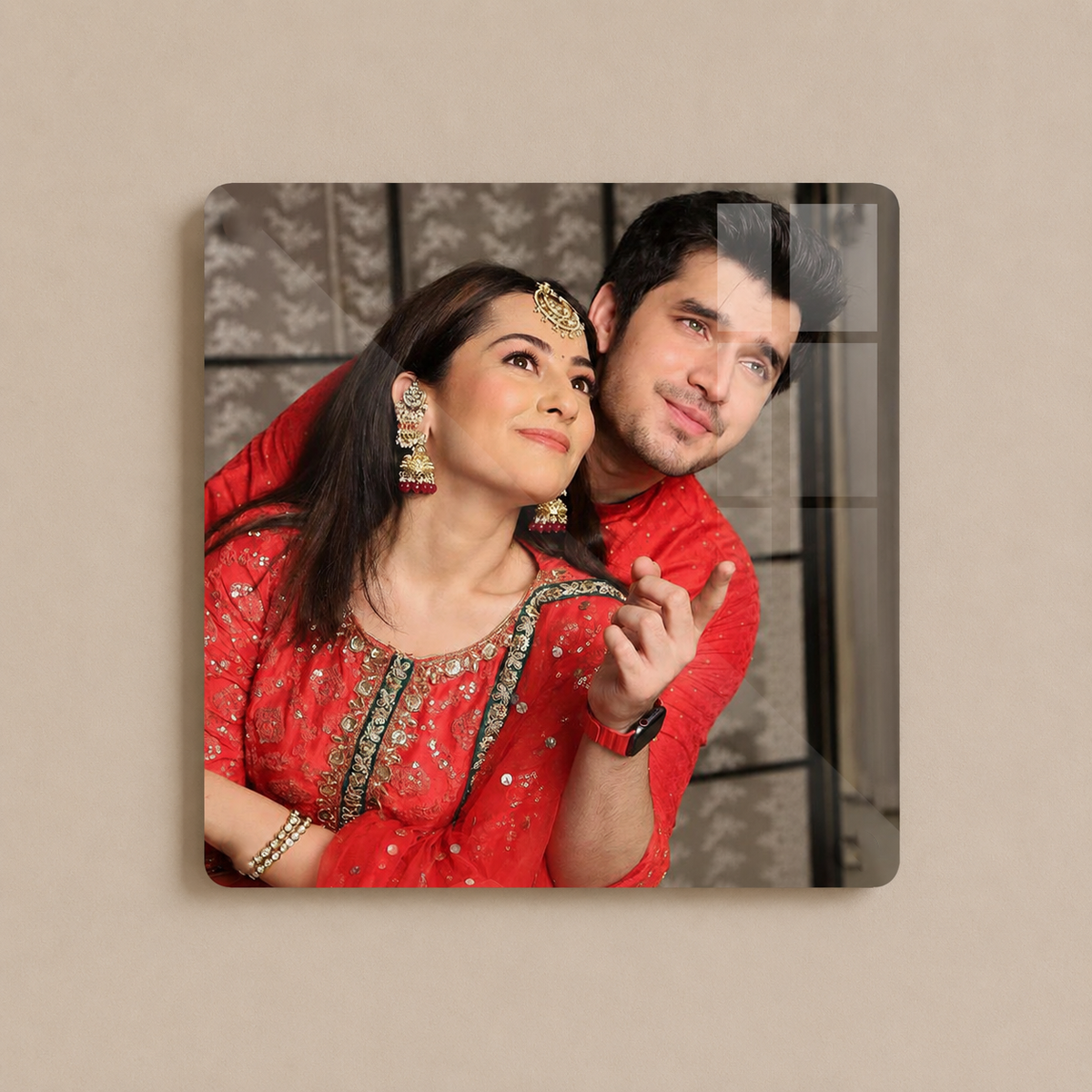 Square acrylic wall photo frame with rounded corners showing a couple in red outfits