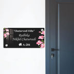 Black acrylic door name plate with floral corner accents, house number A-204