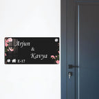 Black acrylic door name plate with cherry blossoms, Arjun & Kayya, E-17; corner bolts
