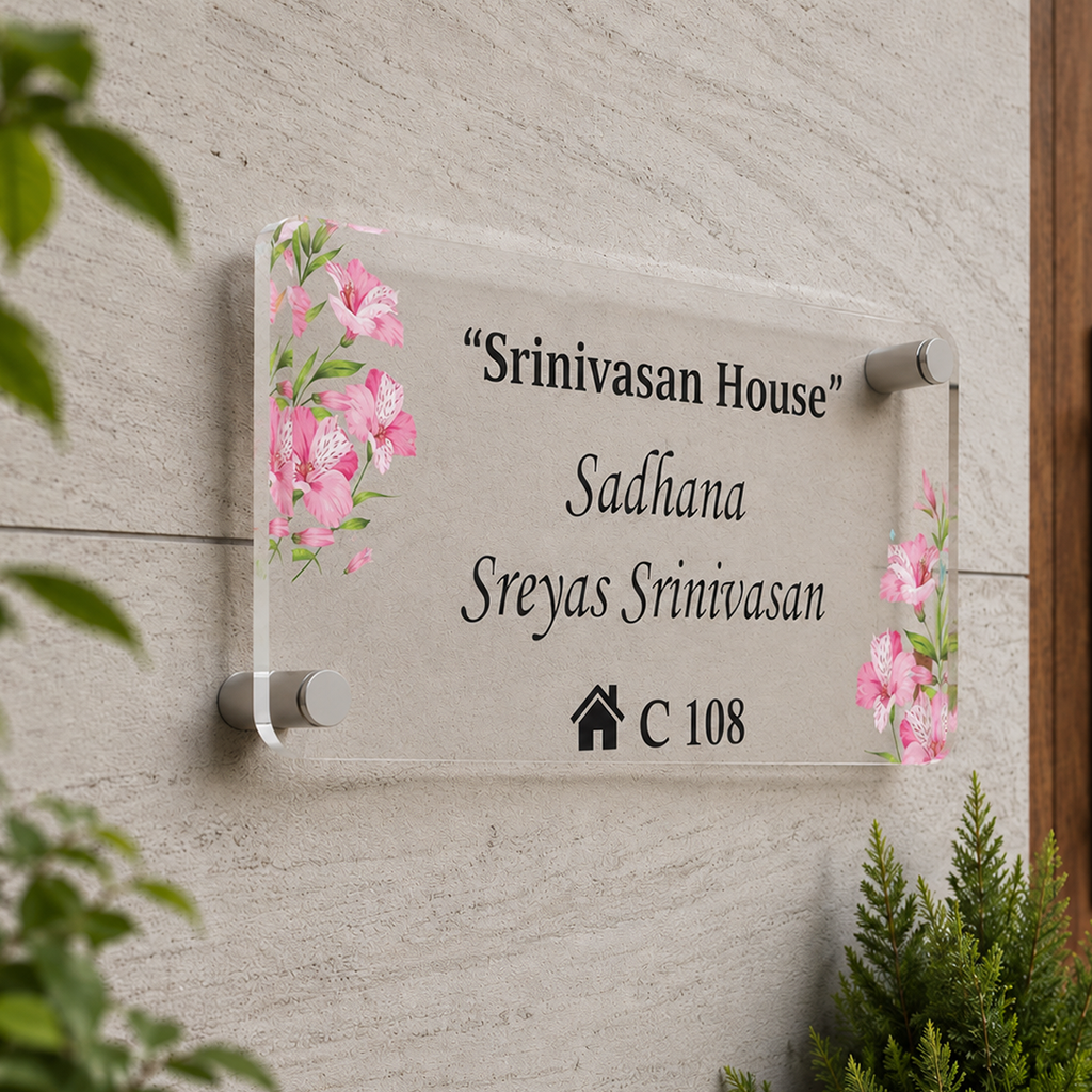 Transparent acrylic door name plate with floral corners and engraved text “Srinivasan House”
