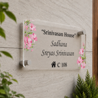 Transparent acrylic door name plate with floral corners and engraved text “Srinivasan House”