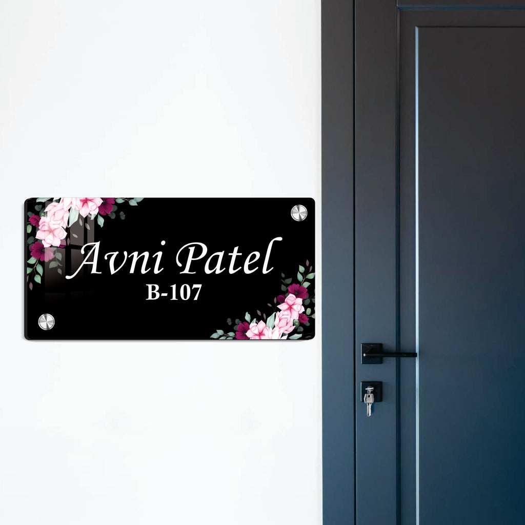 Black door name plate with pink floral corners and name "Avni Patel" B-107