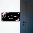 Black door name plate with pink floral corners and name "Avni Patel" B-107