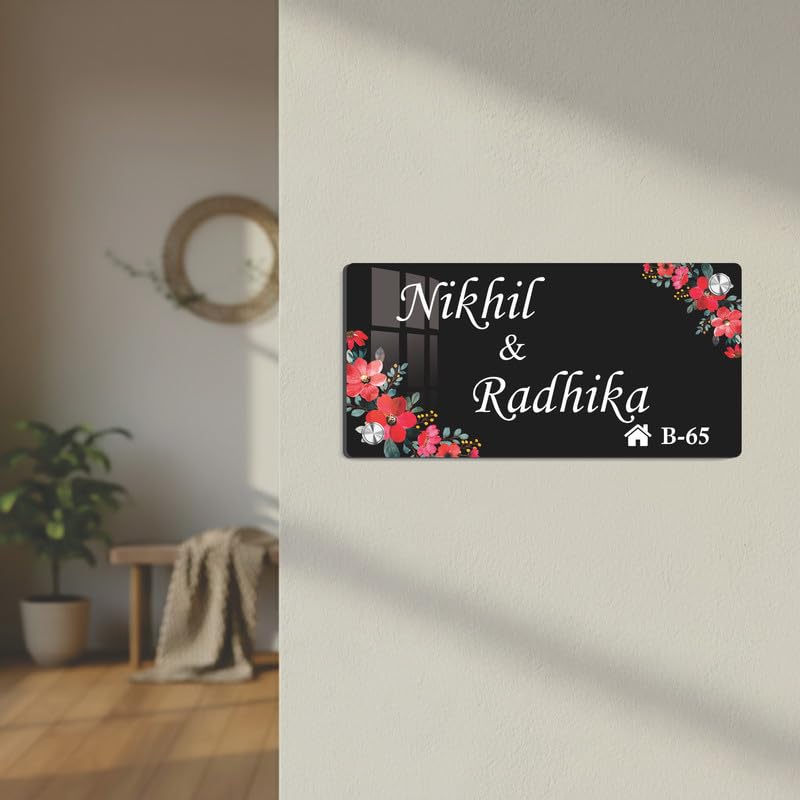Black acrylic door name plate with floral corners and engraved text, Nikhil & Radhika