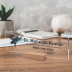 Transparent acrylic desk name plate with Dr. Mohnish Kumar and medical credentials, on wood stand