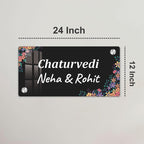 Black acrylic door name plate with floral corners, 24 inch width, text: Chaturvedi, Neha & Rohit