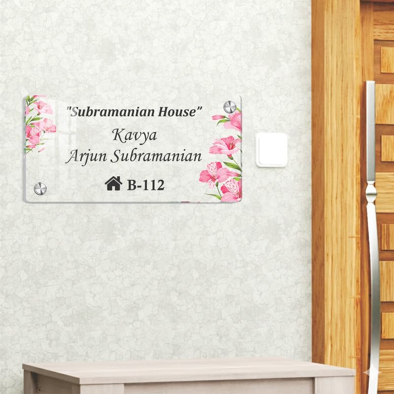 Transparent acrylic door name plate with pink floral corners and “Subramanian House” “B-112”