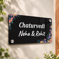 Black acrylic door name plate with floral corners, text: Chaturvedi, Neha & Rohit