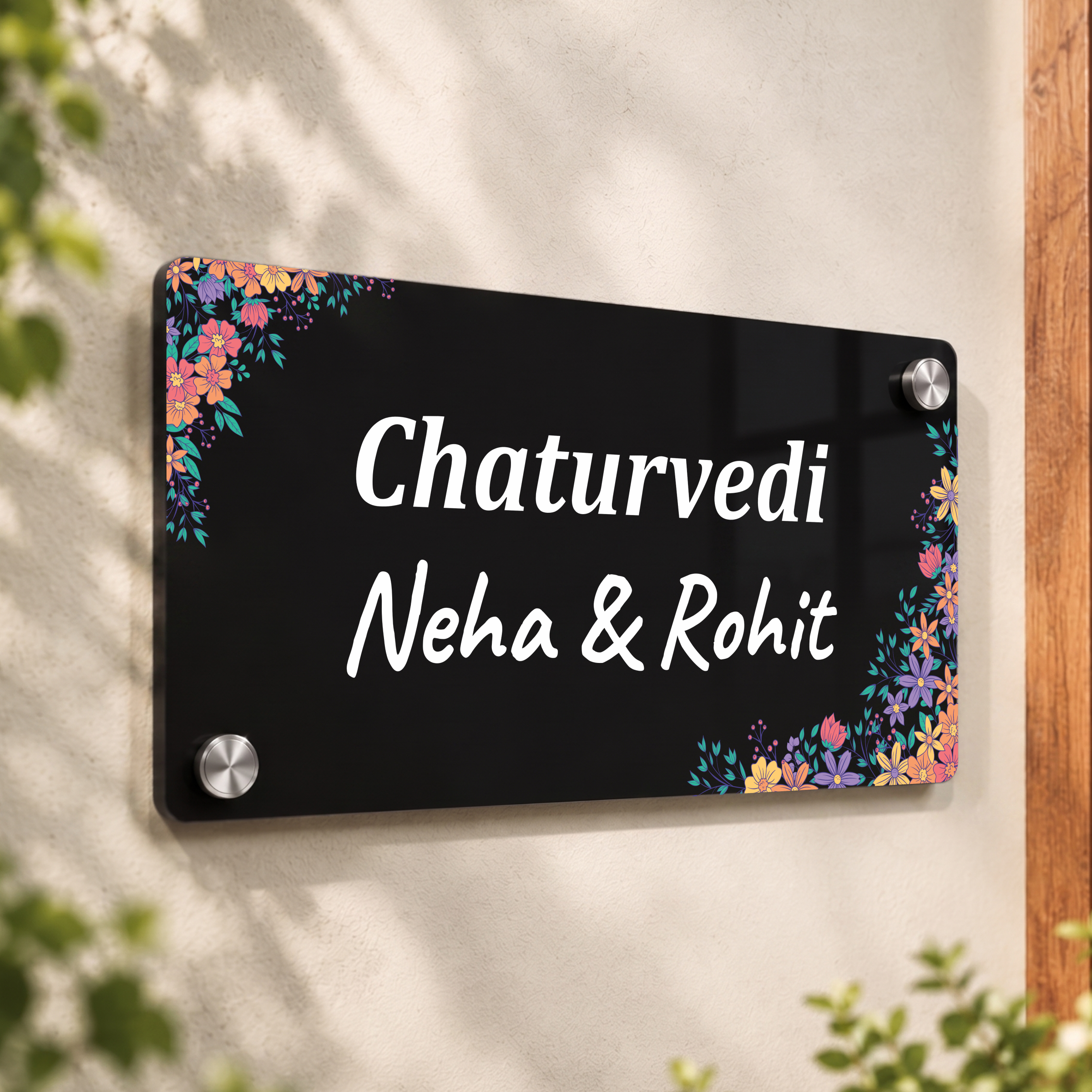 Black acrylic door name plate with floral corners, text: Chaturvedi, Neha & Rohit