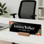 Black acrylic desk name plate with floral border, 'Kristen Walker' and CEO on a wooden stand
