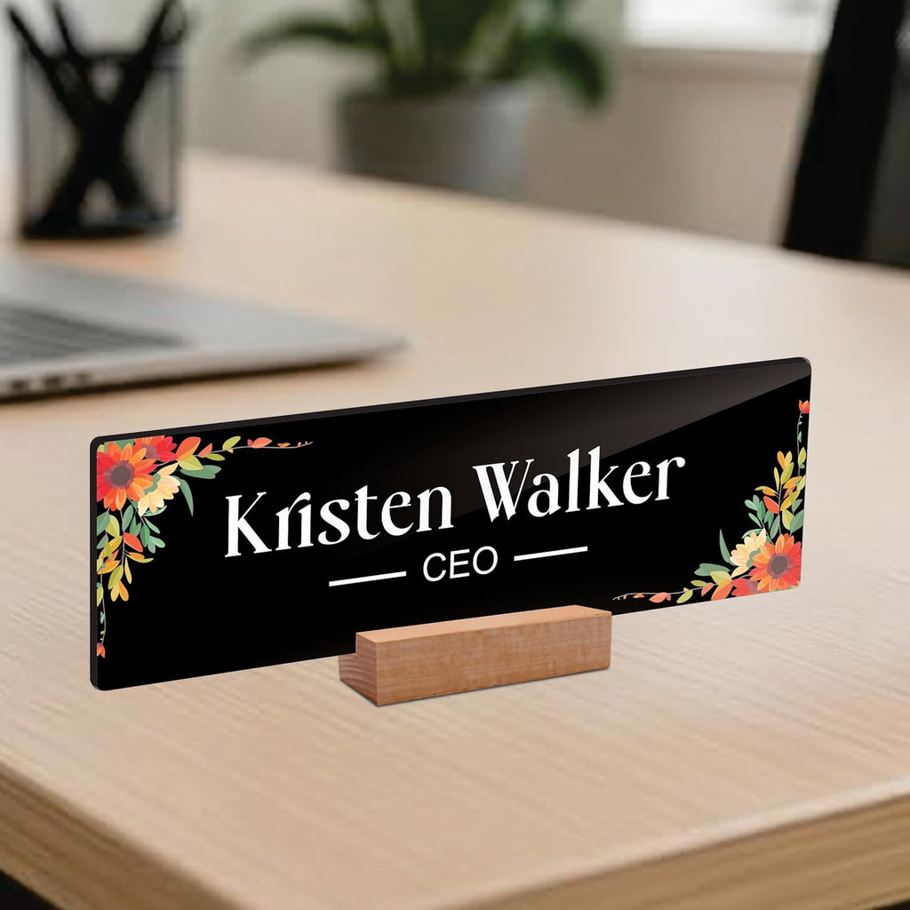 Black acrylic desk name plate with floral corners, 'Kristen Walker' and CEO lettering