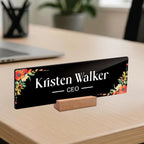 Black acrylic desk name plate with floral corners, 'Kristen Walker' and CEO lettering
