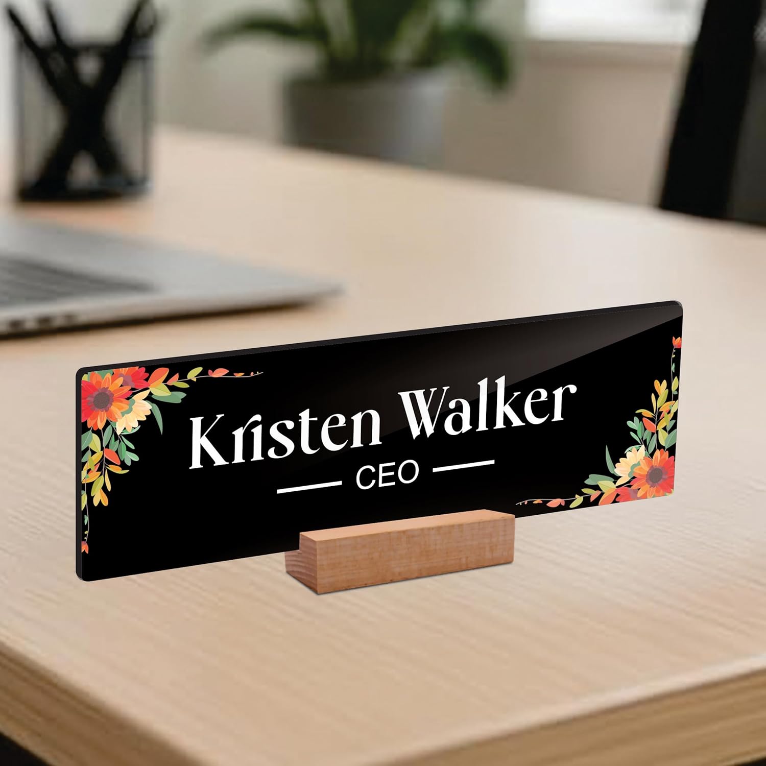 Black acrylic desk name plate with floral corners, 'Kristen Walker' and CEO lettering