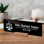 Black acrylic desk plate on wood stand with scales icon: Adv. Suresh Yadav, B.A. LLB