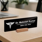Black acrylic desk name plate with white doctor name and caduceus, on wooden stand