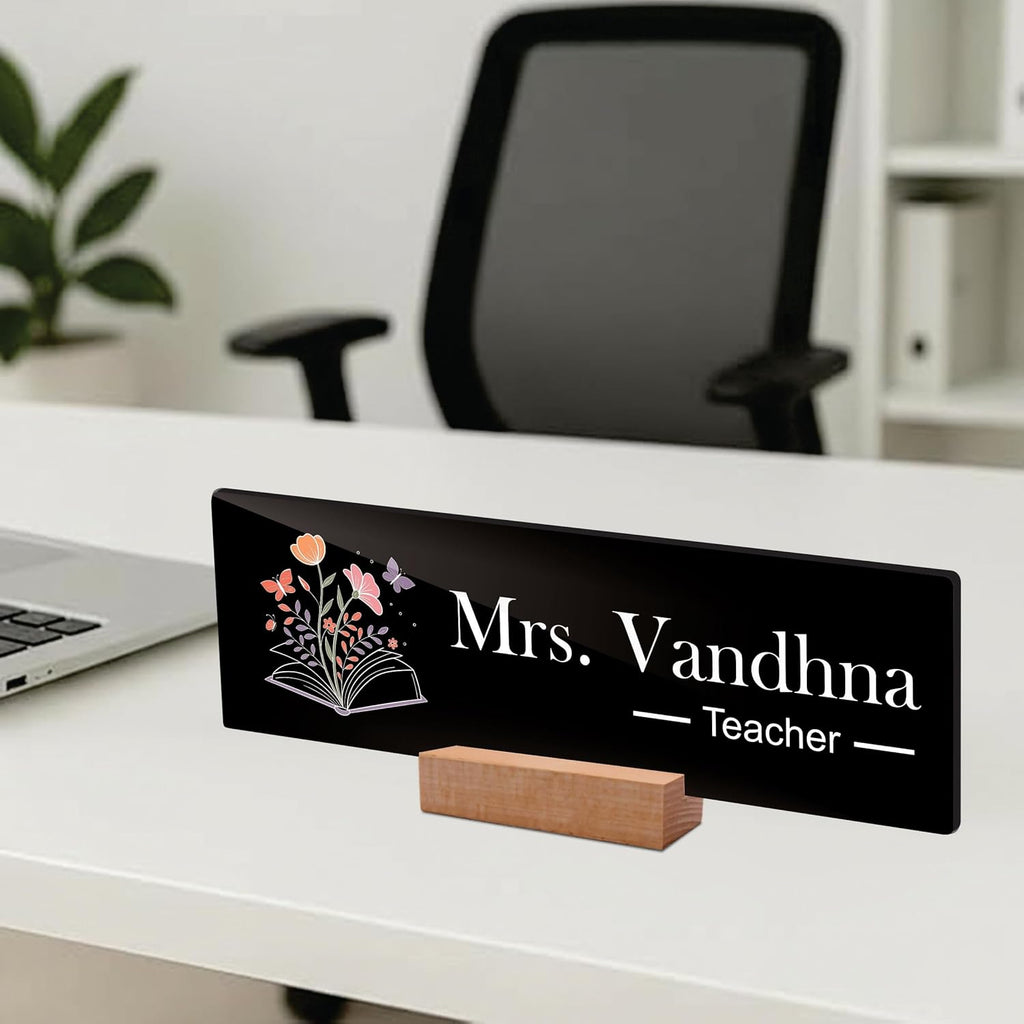 Black acrylic desk name plate, Mrs. Vandhna Teacher with floral book icon and wooden base