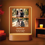 Vertical LED acrylic photo frame with two photos, warm glow outline and wood base