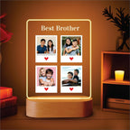 Edge-lit LED acrylic photo frame with four portrait tiles and warm glow, on wood base