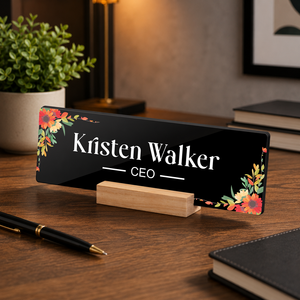Black acrylic desk name plate with floral border, 'Kristen Walker' and CEO on wooden stand