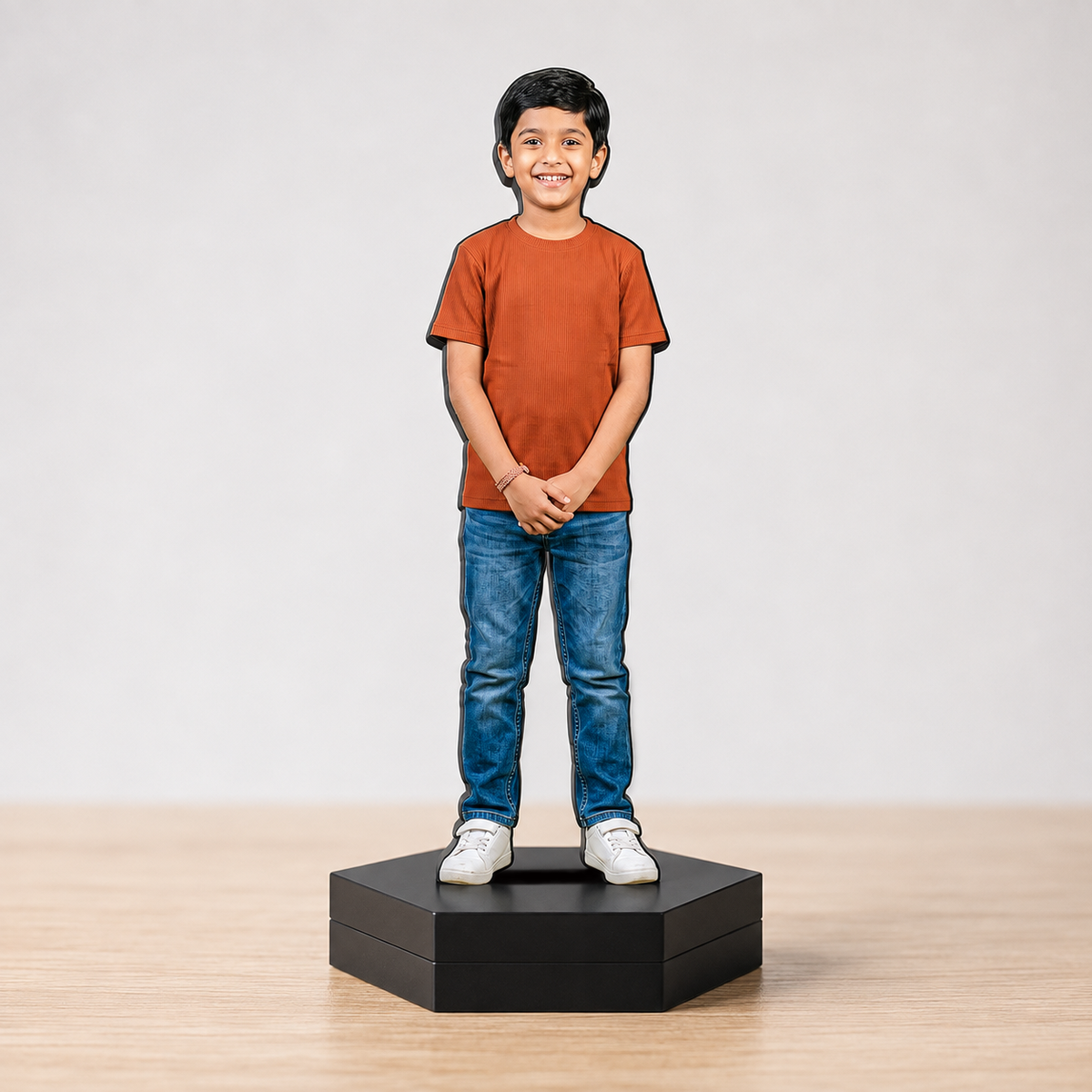 Personalized photo cutout of a boy in an orange shirt on a black base with jeans